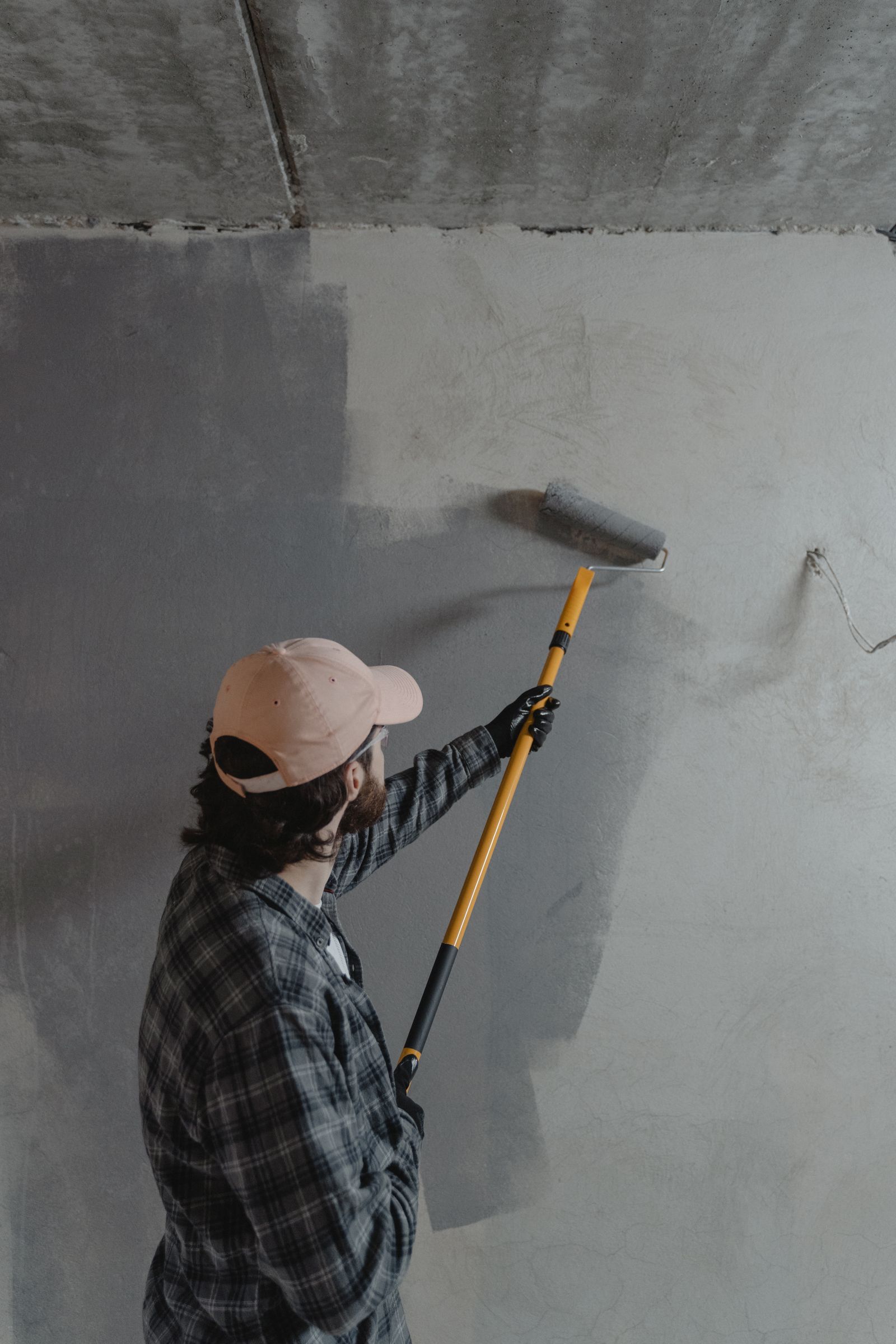 Painter rolling paint onto an interior wall